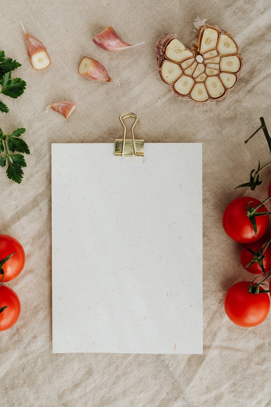 blank clipboard with fresh vegetables and herbs on table